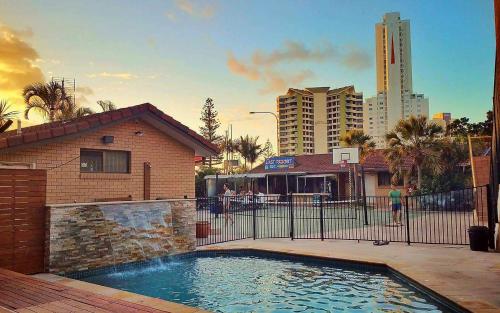 a swimming pool in front of a building at Maxmee Backpackers Resort in Gold Coast