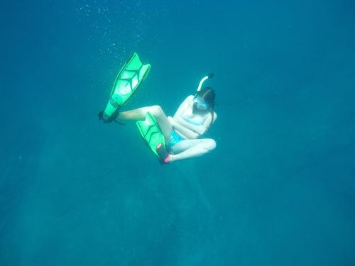 a woman is swimming in the water with a diver at Casa Oro Eco Hostel in San Juan del Sur