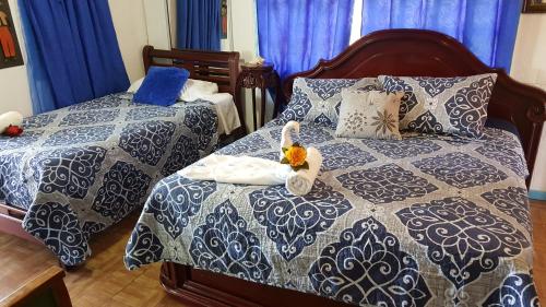 a bedroom with two beds with blue and white at Posada Nativa Licy in San Andrés