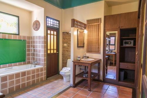 a bathroom with a tub and a toilet and a sink at West Key Kamala Villa in Kamala Beach