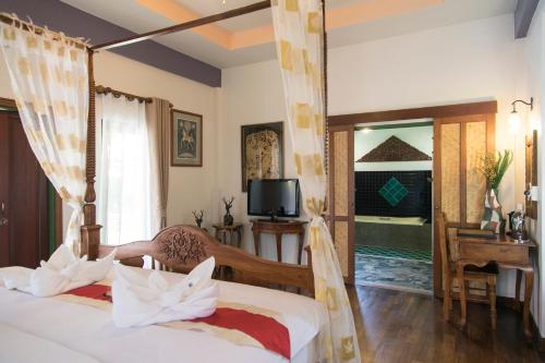a bedroom with two beds and a tv and a window at West Key Kamala Villa in Kamala Beach