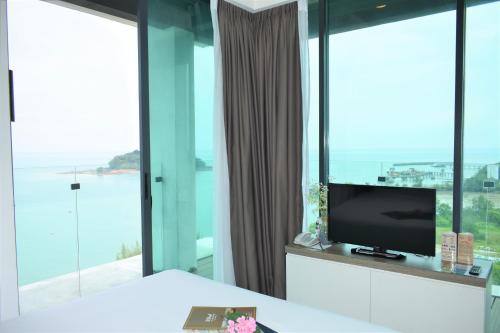 a bedroom with a bed and a tv and windows at D'Wharf Hotel & Serviced Residence in Port Dickson