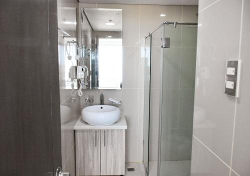 a bathroom with a sink and a glass shower at Alicia Apartelle in Cebu City