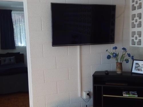 a flat screen tv hanging on a brick wall at Redwood Lodge Motel in Levin