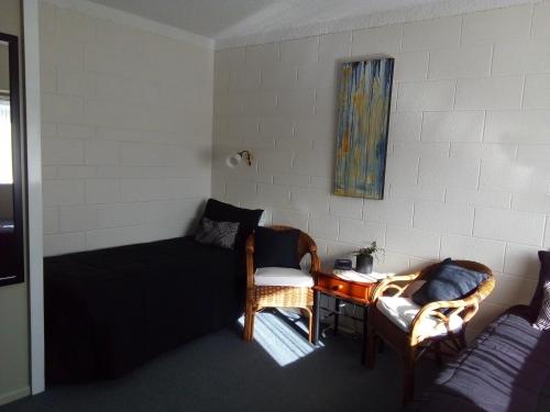 a room with a bed and a table and chairs at Redwood Lodge Motel in Levin