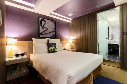 a hotel room with a large bed and a window at V-one Vogue Hotel in Taipei