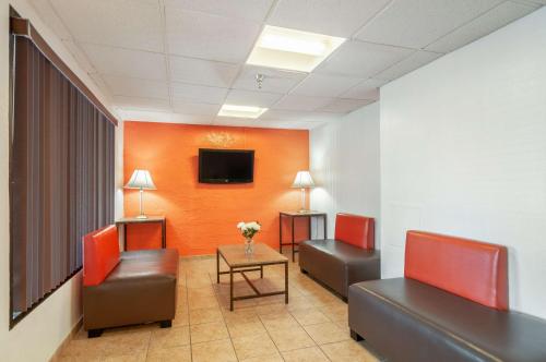 a waiting room with two chairs and a tv on a wall at Motel 6-Naperville, IL in Naperville