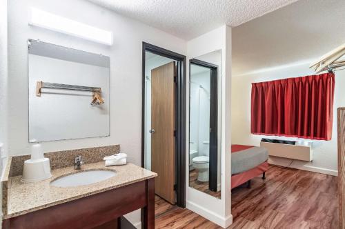 a bathroom with a sink and a bedroom with a bed at Motel 6-Naperville, IL in Naperville