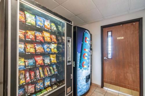 a room with a refrigerator full of chips and a snowboard at Motel 6-Naperville, IL in Naperville