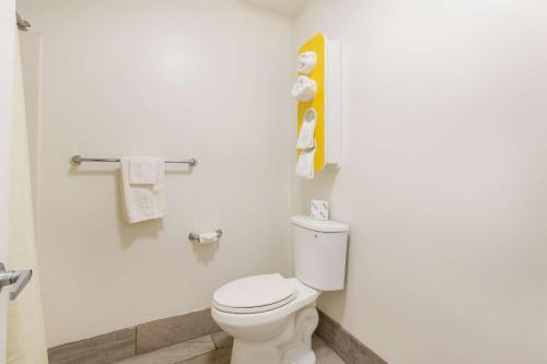 a bathroom with a toilet and towels on the wall at Motel 6-Greenville, SC in Greenville