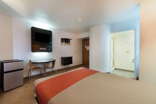 a bedroom with a bed and a desk and a tv at Motel 6-Dallas, TX - Northeast in Garland