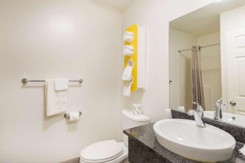 Baño blanco con lavabo y aseo en Motel 6-Greenville, SC, en Greenville
