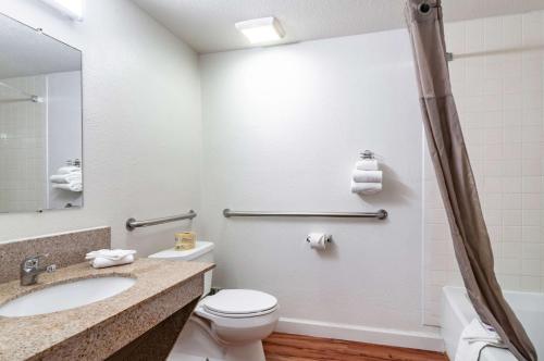 a bathroom with a toilet and a sink and a mirror at Motel 6-Naperville, IL in Naperville