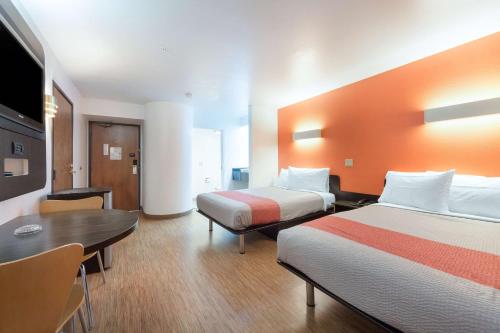 a hotel room with two beds and a table at Motel 6-Dallas, TX - Northeast in Garland