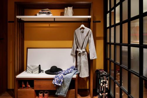 a closet with a coat and hat on a shelf at Hyatt Centric Ginza Tokyo in Tokyo