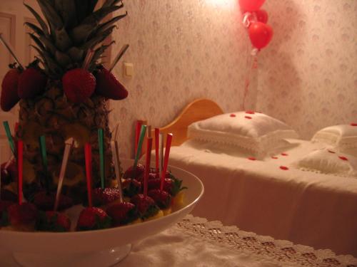 a table with a cake and a bowl of strawberries at Saule in Talsi