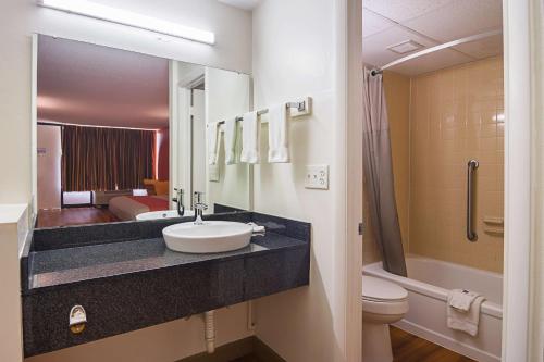 een badkamer met een wastafel, een toilet en een douche bij Motel 6-Cleveland, TN in Cleveland