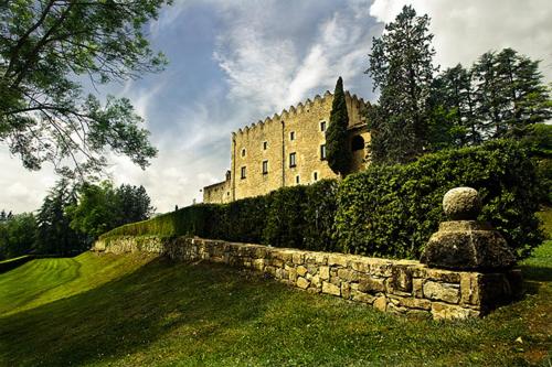 a large building on a hill with a stone wall at Hotel Sant Quirze De Besora in Sant Quirze de Besora