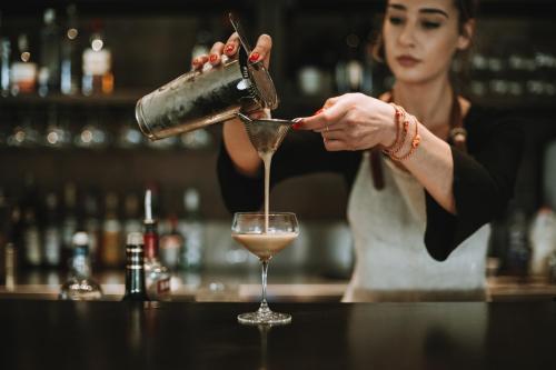 a woman pouring a drink into a wine glass at Polperro Villas in Red Hill