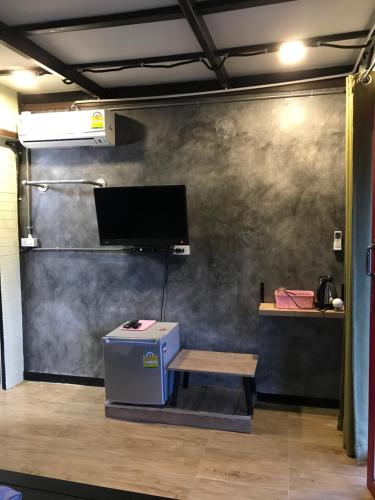a room with a table and a tv on a wall at Sida Homemade in Chiang Khan