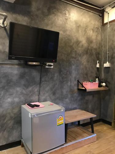 a flat screen tv on a wall with a table at Sida Homemade in Chiang Khan