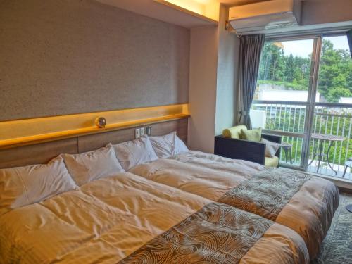 Hotel Spax Kusatsu tesisinde bir odada yatak veya yataklar