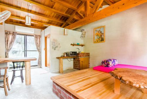 a living room with a bed and a table at Lungta BnB in Jiufen