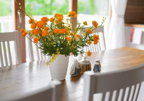 un jarrón de flores naranjas sentado en una mesa en Vasekoja Holiday Center en Vahtseliina