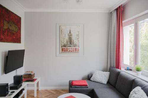 ワルシャワにあるASKI Hoża Apartmentのリビングルーム(ソファ、テレビ付)