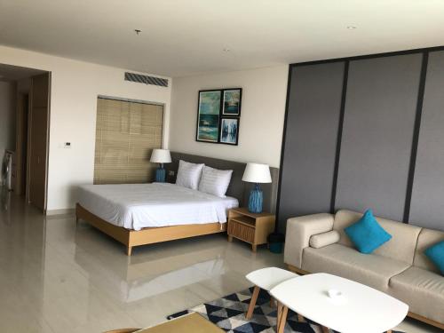 a hotel room with a bed and a couch at One Bedroom Apartment with Sea View in Danang