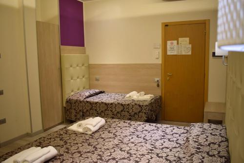 a hotel room with two beds with towels on them at Hotel Baffo Rosso in Alba Adriatica
