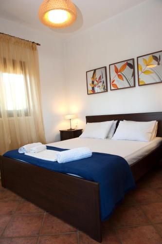 a bedroom with a large bed with two towels on it at Apartments Villa L&M Skiathos in Skiathos Town