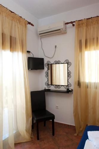 a room with a mirror and a chair and a window at Apartments Villa L&M Skiathos in Skiathos Town