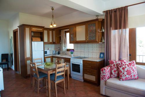 a small kitchen with a table and a couch at Apartments Villa L&M Skiathos in Skiathos Town