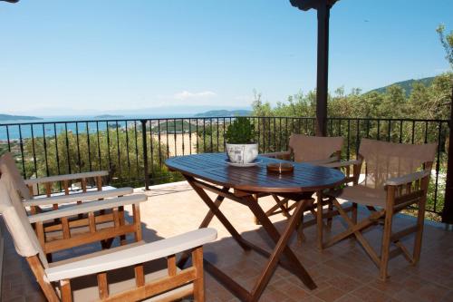 a wooden table and chairs on a patio at Apartments Villa L&M Skiathos in Skiathos Town