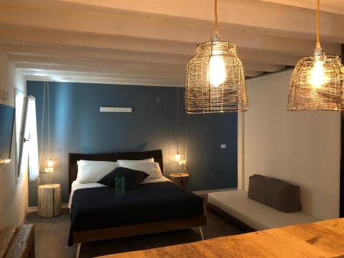 1 dormitorio con 1 cama y 2 luces colgantes en Kibò Urban Lodge Chioggia Adults Only, en Chioggia