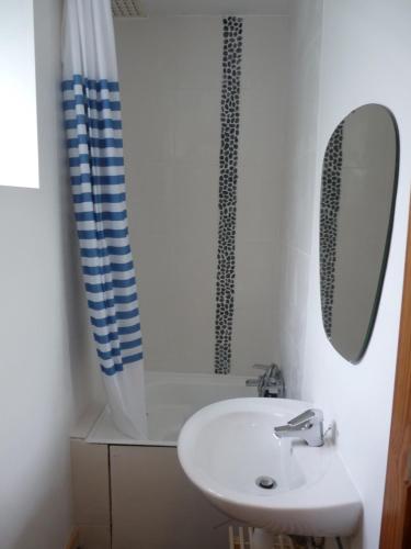 La salle de bains blanche est pourvue d'un lavabo et d'un miroir. dans l'établissement Gîte Aische-en-Refail, à Aische-en-Refail