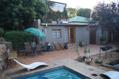 a backyard with a swimming pool and a house at Westmoreland Lodge in Johannesburg