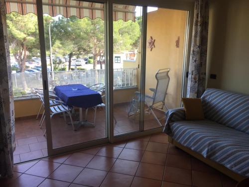 sala de estar con sofá y mesa en el balcón en CasaRoberta, en Marina di Campo