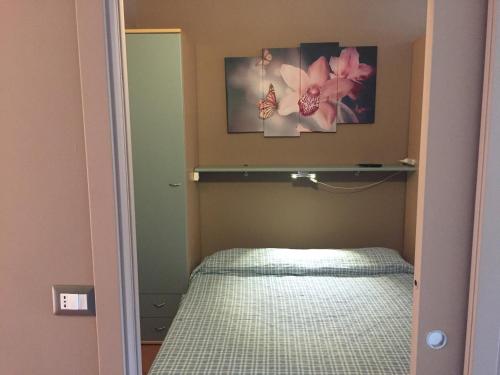 Dormitorio pequeño con cama y espejo en CasaRoberta, en Marina di Campo