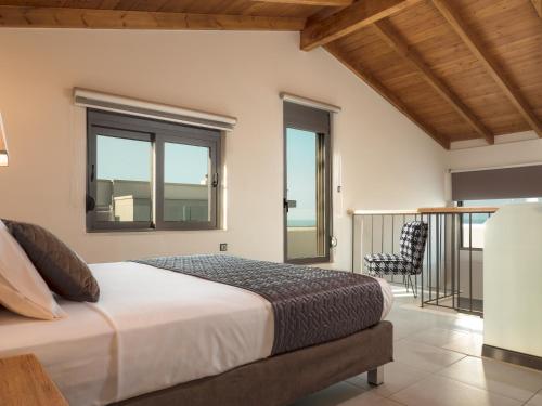 a bedroom with a bed and a balcony at Dempla Heights Villas in Tavronitis