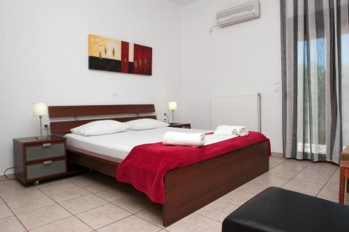 a bedroom with a large bed with a red blanket at Apartments Villa L&M Skiathos in Skiathos Town