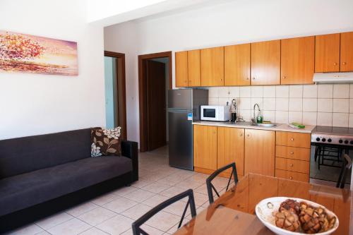a kitchen and a living room with a couch and a table at Apartments Villa L&M Skiathos in Skiathos Town