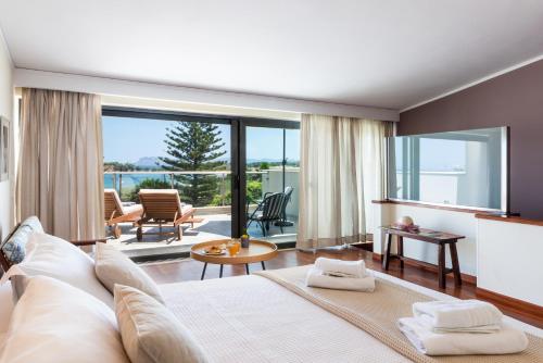 a bedroom with a large bed and a large window at Villa Ismini in Kato Daratso