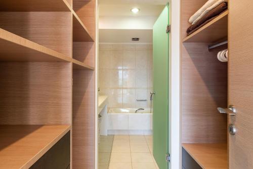 a bathroom with wooden shelving and a walk in shower at Villa Ismini in Kato Daratso