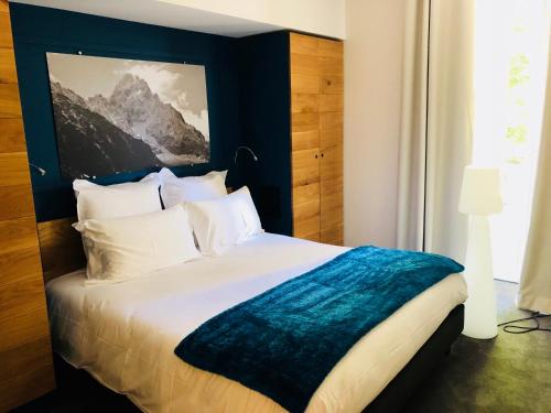 a bedroom with a large bed with a blue headboard at Appart'Hotel Aiguille Verte & Spa in Chamonix-Mont-Blanc