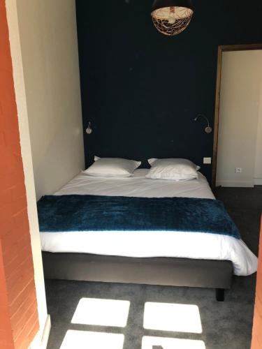 a bed with two pillows and a blue blanket at Appart'Hotel Aiguille Verte & Spa in Chamonix-Mont-Blanc