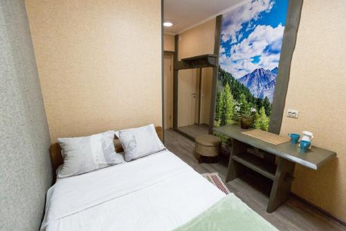 una camera con letto e scrivania con quadro di Hotel Shumak a Ulan-Ude