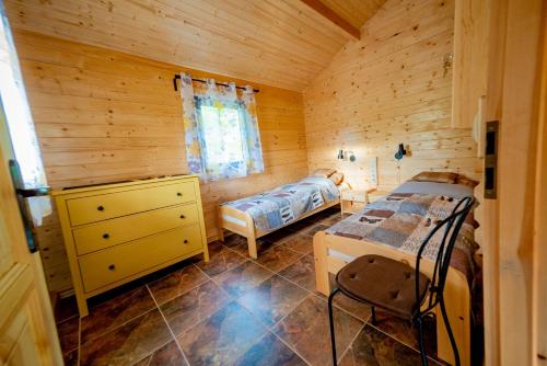 um quarto com 2 camas num chalé de madeira em Chata na Polanie em Tarnowo