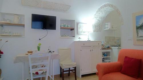 a living room with a table and a kitchen at Trullo Sereno Angelo in Locorotondo